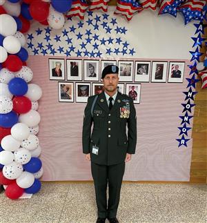 Mr Watkins in his uniform with other military families in the background