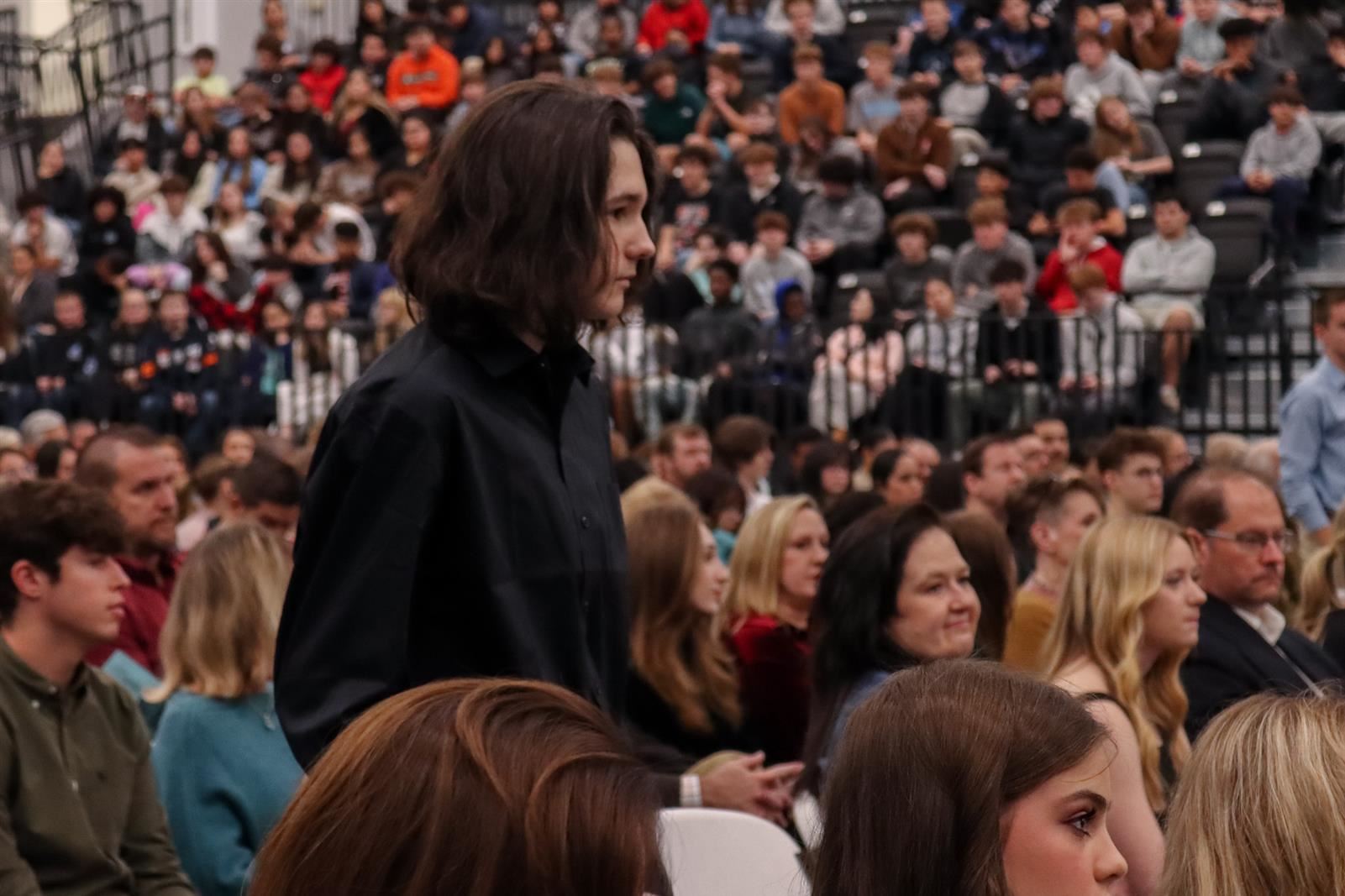 male student standing in crowd